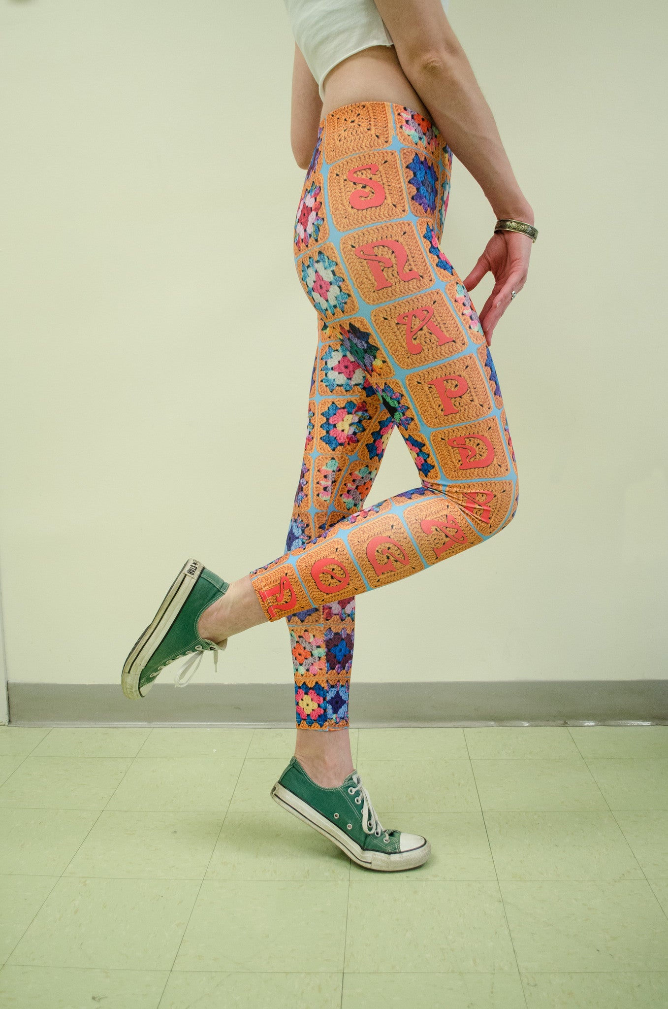 Snapdragon Brand Clothing Granny Square Crochet Print gold leggings in style Snappy features a 1970s vintage feel and a rainbow of colors. Made of comfortable spandex.